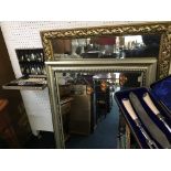 A mirror with orange decoration, a gold framed mirror and two boxes of cutlery.