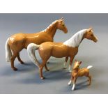 Two Beswick palomino horses with one foal.