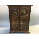 An oak smokers cabinet with brass handles.