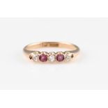A ruby and diamond five stone ring, set with three round cut diamonds and two round cut rubies,