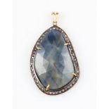 A sapphire and diamond pendant, set with a polished piece of sapphire, surrounded by a border of