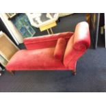 A pink upholstered oak framed chaise longue.