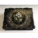 A black papier mache travel writing box with pearl inlay floral decoration.