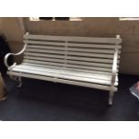 A white painted scroll arm garden bench.