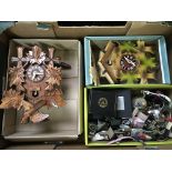 Two wooden cuckoo clocks with a box of watches.