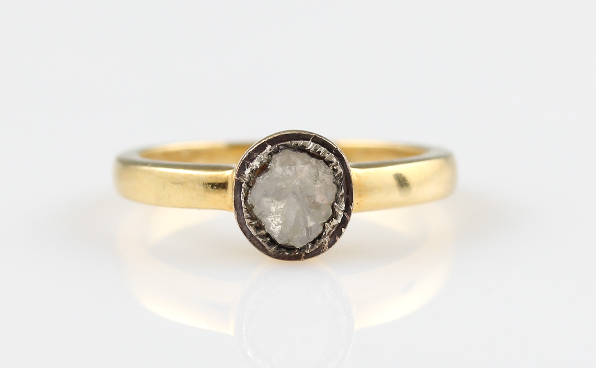 A diamond ring, set with a foil backed flat cut diamond, in unmarked yellow metal, ring size L½.