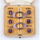 A set of two enamel buckles and six enamel buttons, housed in a fitted case.