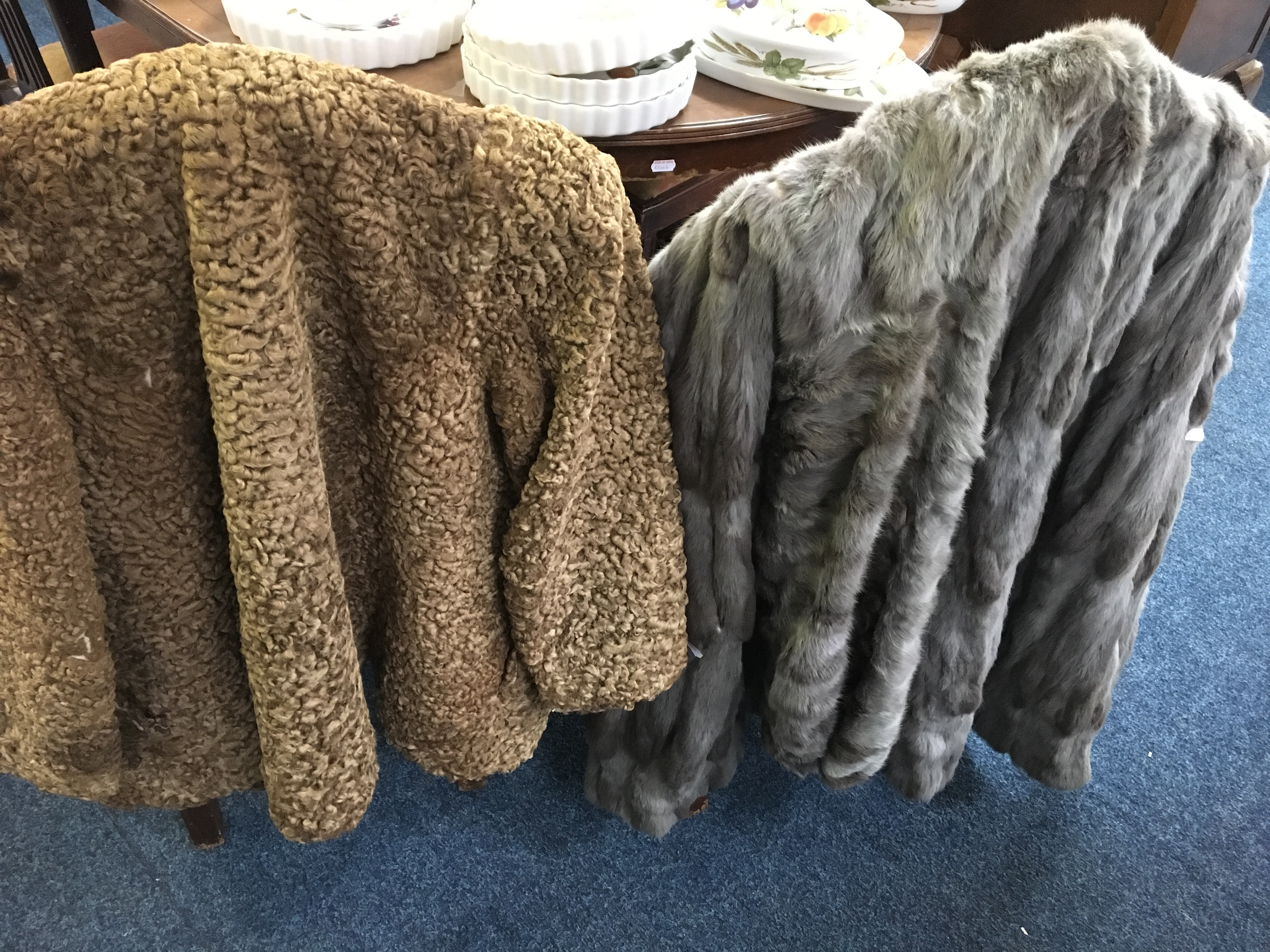 Two fur coats, one grey Miatto, one brown Merrick Furriers.