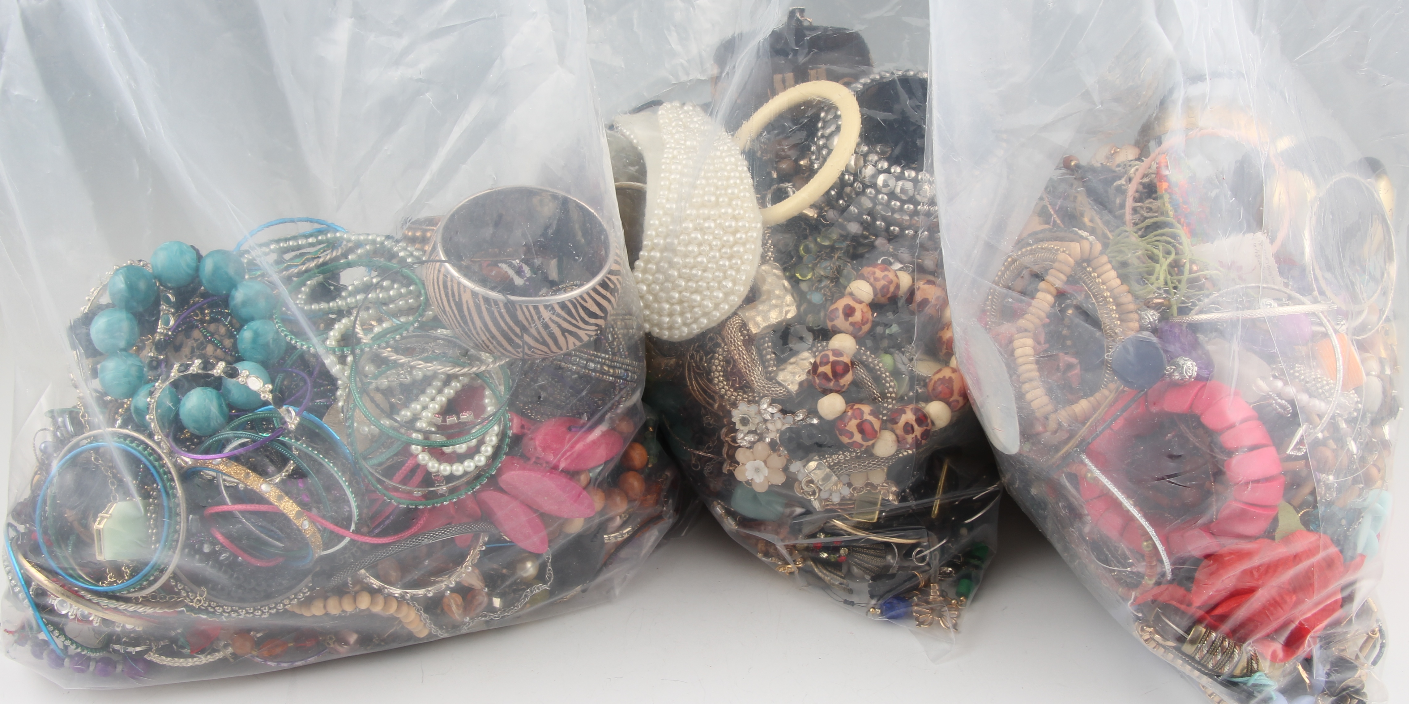 Three bags of costume jewellery to include bangles, beads, necklets, earrings etc.