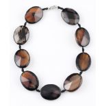 A banded agate necklet, comprising of nine oval faceted banded agates, each measuring approx.