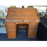 An Indianapolis Cabinet Co. golden oak roll top writing desk fitted with eight drawers.