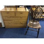 A two short and two long drawer chest with two chairs.