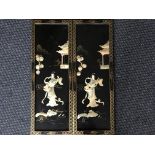A pair of black lacquered panels with gold painted and mother of pearl effect Japanese design.