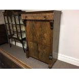 A mahogany escritoire cabinet with scroll detail.