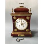 A mock tortoiseshell mantel clock with brass details. Height 35cm.