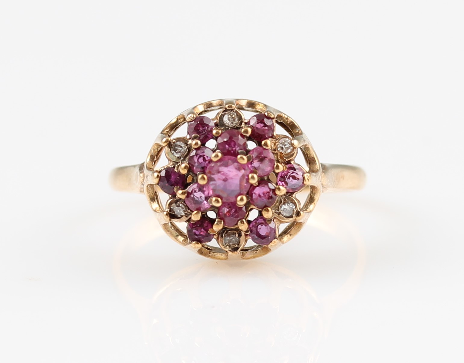 A 9ct yellow gold ruby and diamond tiered cluster ring, set with two tiers of round cut rubies,