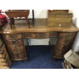 A mahogany serpentine front desk fitted with nine drawer, leather top and raised on bracket feet.