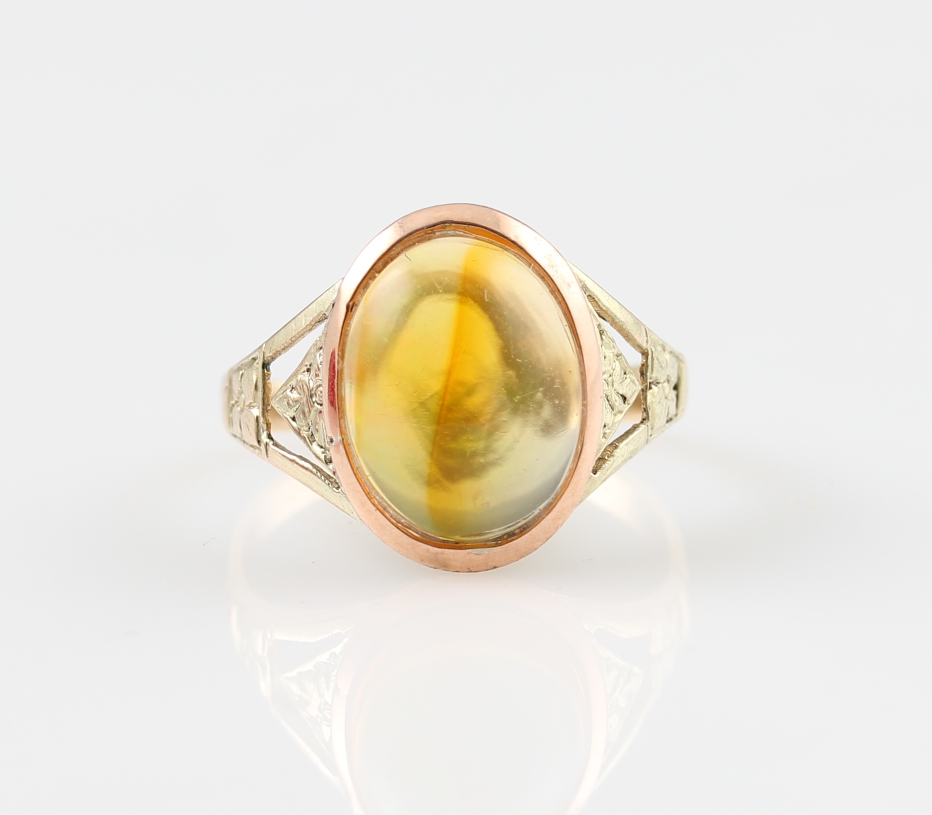 A fire opal ring, set with an oval fire opal cabochon, in an open metalwork setting, set in unmarked