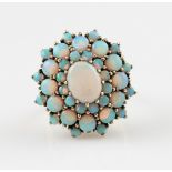 A 9ct yellow gold tiered opal cluster ring, set with a central oval opal cabochon surrounded by