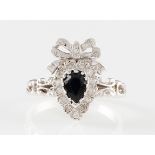 *A modern 9ct white gold sapphire and diamond ring, the central pear cut sapphire surrounded by a