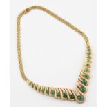 An emerald and diamond necklet, set with 21 graduated oval emerald cabochons, the largest