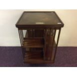 A mahogany revolving bookcase with silver plaque to top dated 1901.