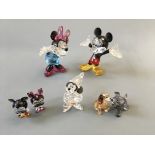 Two sets of Swarovski Mickey Mouse and Minnie Mouse figurines, one set miniature, with The Sorcerers