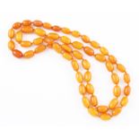 A knotted string of graduated butterscotch amber beads, comprising of approx. 52 oval amber beads,