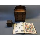 A Victorian miniature chest of drawers, tea caddy and book of stamps.