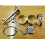 A collection of hallmarked silverware to include a buckle bangle, a vesta case, a filled bud vase,