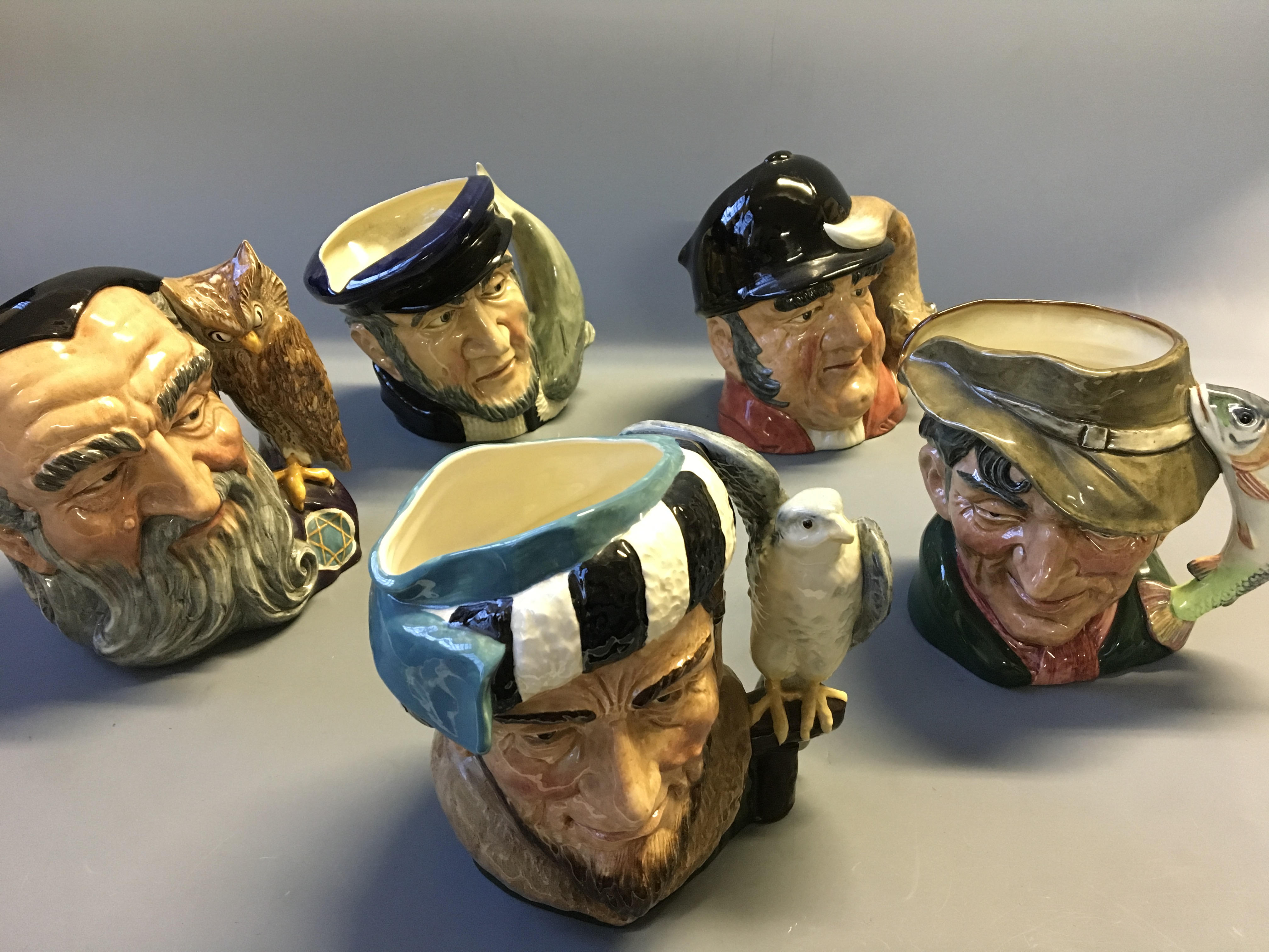 Five Royal Doulton character jugs, The Falconer, The Poacher, Merlin, Capt Ahab and Gone Away.