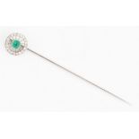 A French emerald and diamond stick pin, the wheel design set centrally with an emerald cabochon,