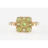 *A 9ct yellow gold peridot ring, set with nine variously sized round cut peridots, hallmarked