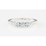 A 9ct white gold topaz and diamond ring, set with three round cut topaz, flanked to either side with