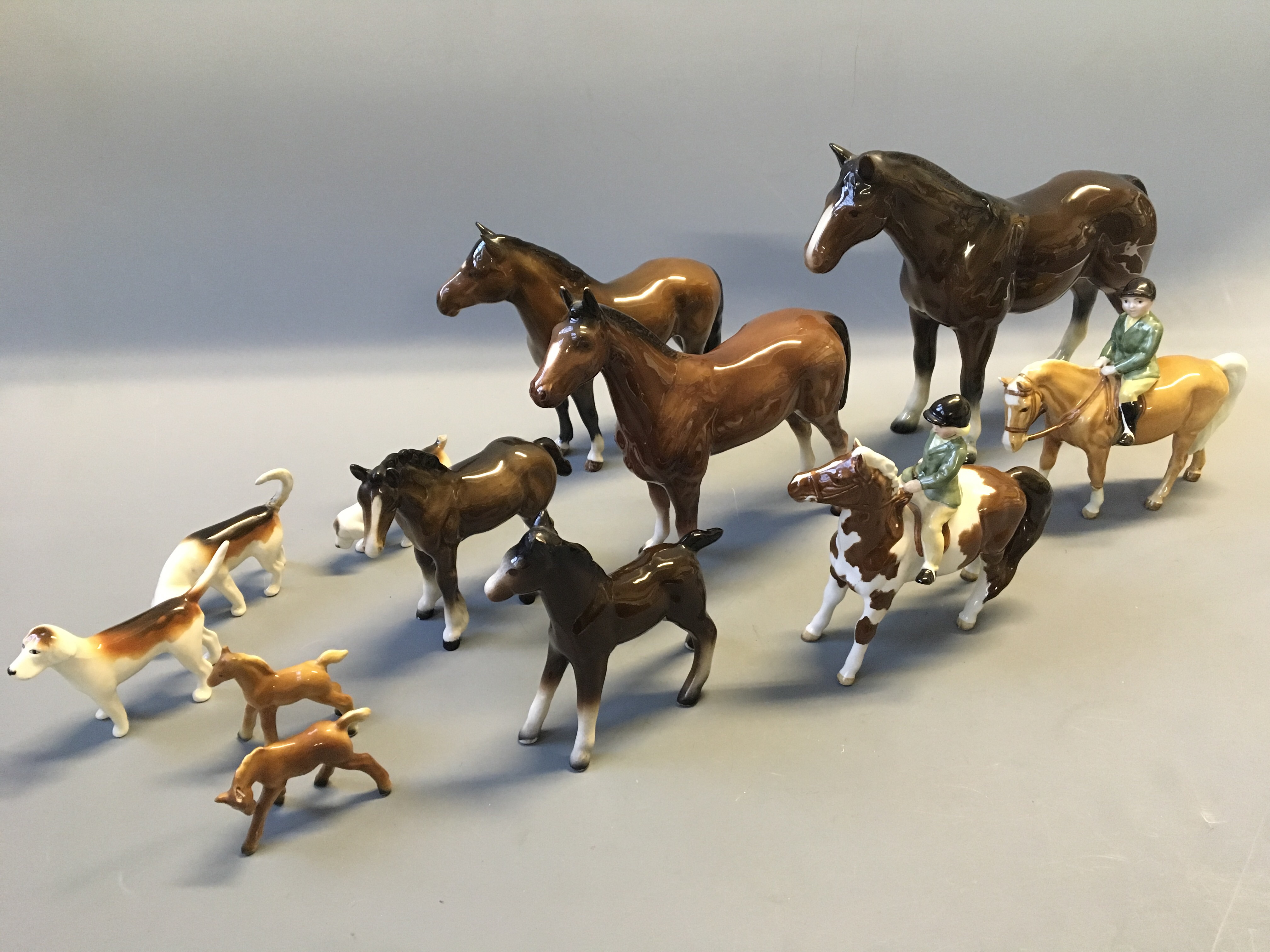 Nine various horse figurines, some Beswick, with three Beswick hunting dogs.