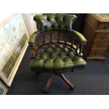 A green leather upholstered captains chair.