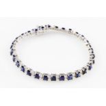 A sapphire (possibly synthetic) line bracelet, with rectangular cut sapphires interspersed with