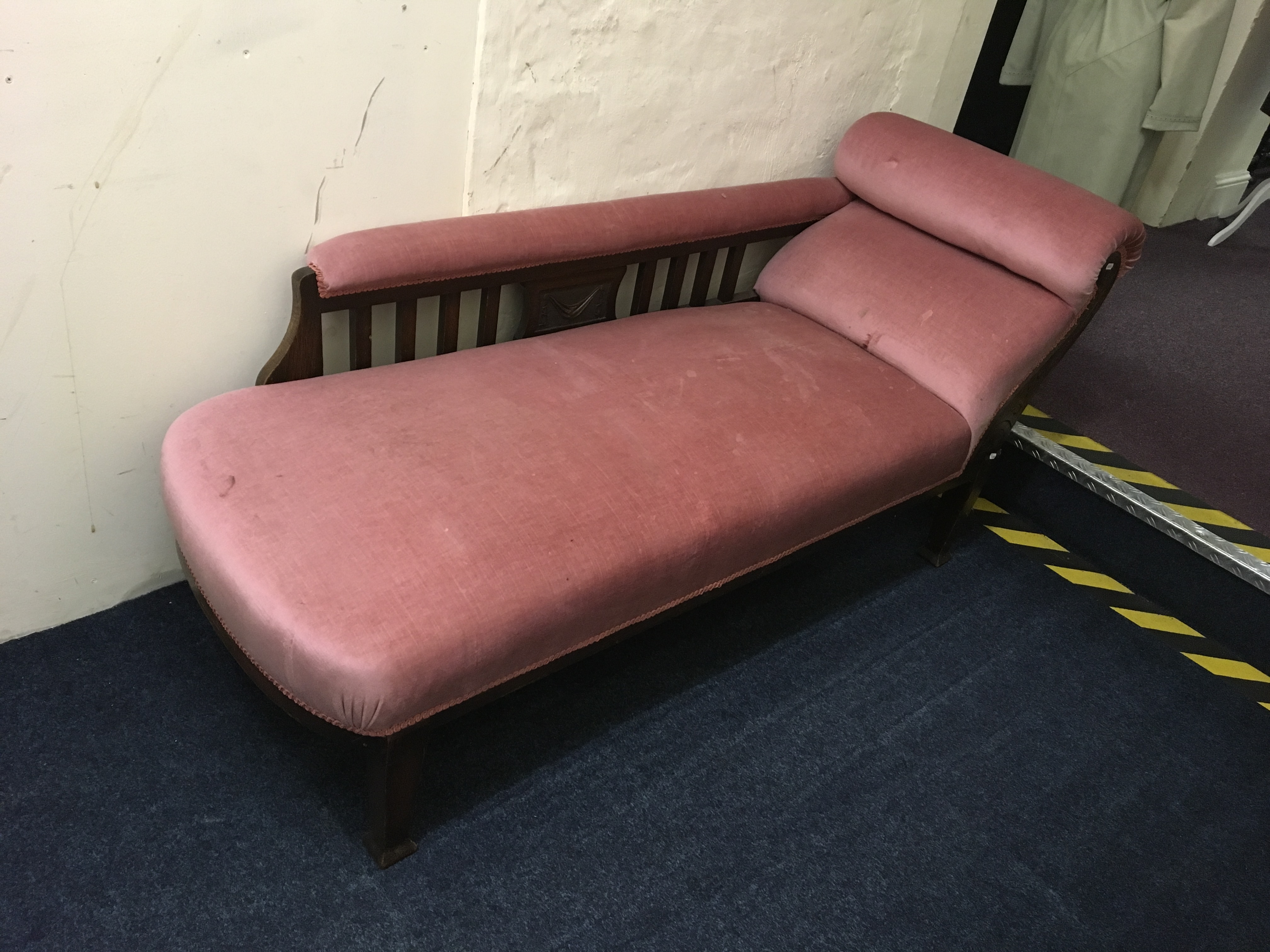 A pink upholstered chaise longue.