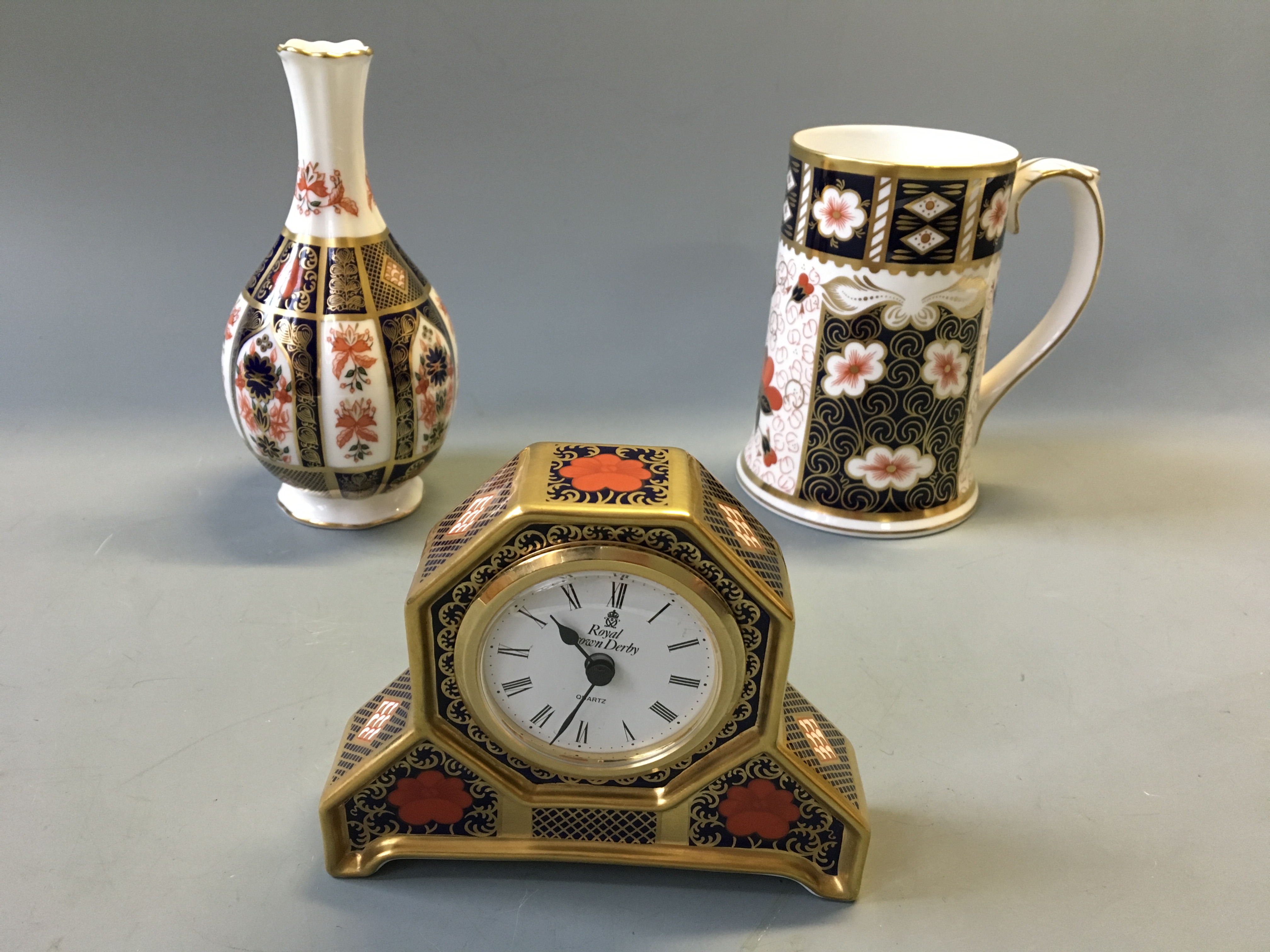A Royal Crown Derby Old Imari mantel clock and orchid vase, with a Traditional Imari tankard.
