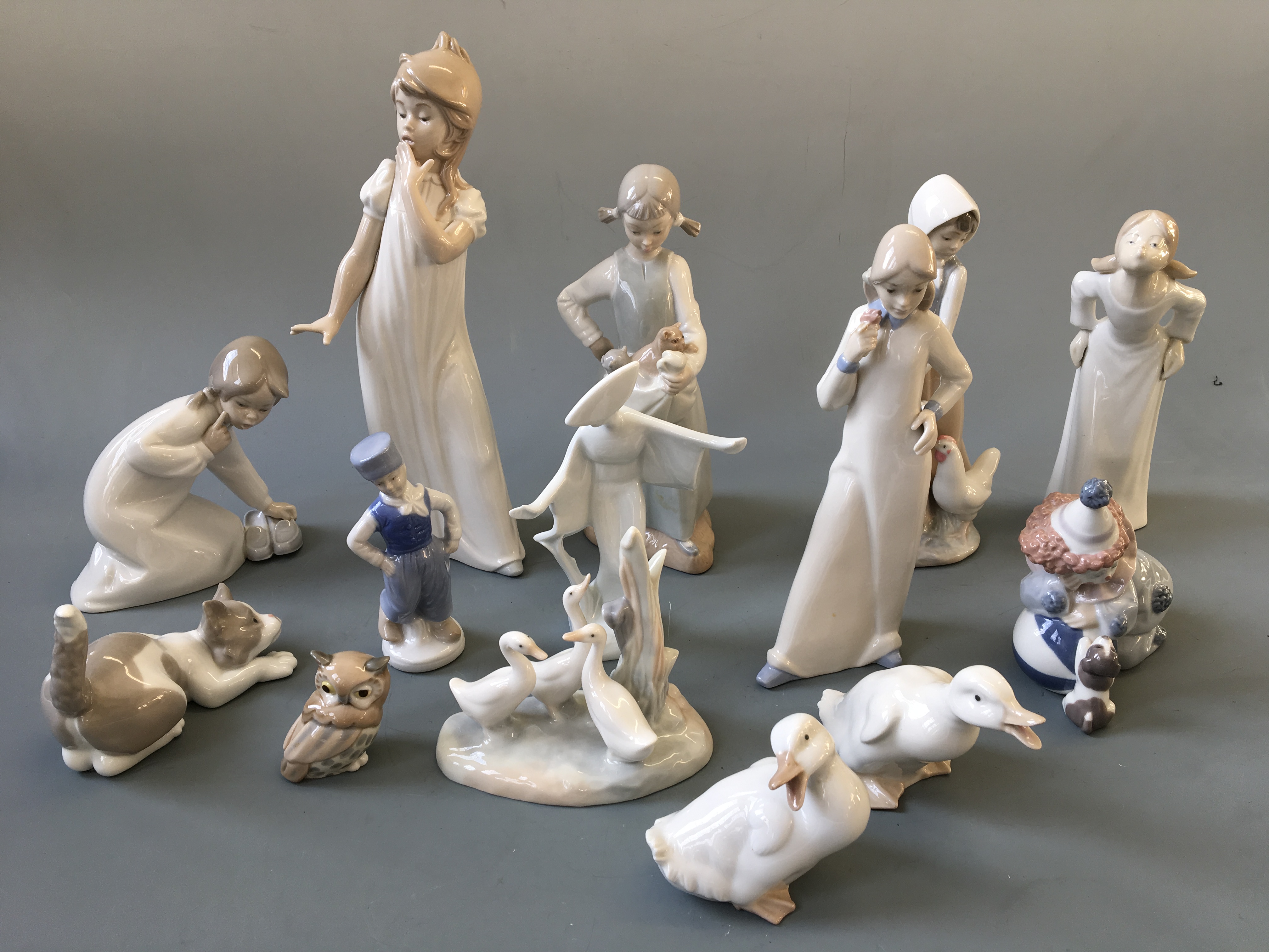 A selection of figurines to include seven Nao and three Lladro depicting girl with kittens, clown,