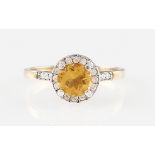 *A 9ct yellow gold citrine and diamond ring, set with a central round cut citrine, surrounded by a