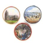 Three reverse glass decorated disc form pincushions, comprising ñWeymouth _ The Bay, Cliffs and
