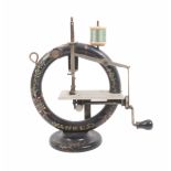 A late 19th Century miniature sewing machine ñYankeeî circular painted wooden frame and base,