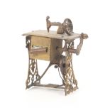 A gilt brass novelty tape measure in the form of a treadle sewing machine complete printed tape,