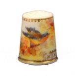 A 19th Century English porcelain thimble attributed to Worcester painted with a bird amid flowers
