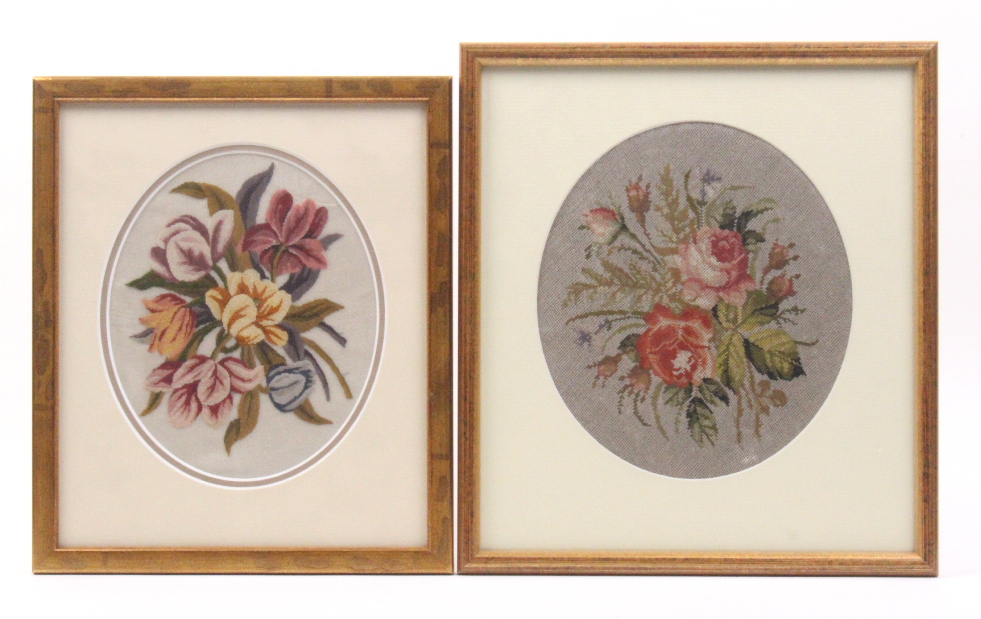 Two 19th Century oval floral needlework embroidered panels, both later mounted glazed and framed,