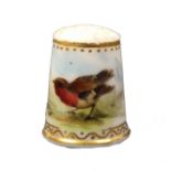 A 19th Century English porcelain thimble, Ex Holmes collection painted with a bird in a landscape