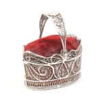 A Georgian silver filigree basket form pincushion, the base and sides with quill work panels, the