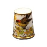 A 19th Century English porcelain thimble Ex Holmes collection painted with a bird on a leafy branch,