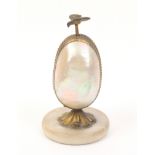 A French table etui for a child or doll, the mother of pearl egg form body in gilt metal mount